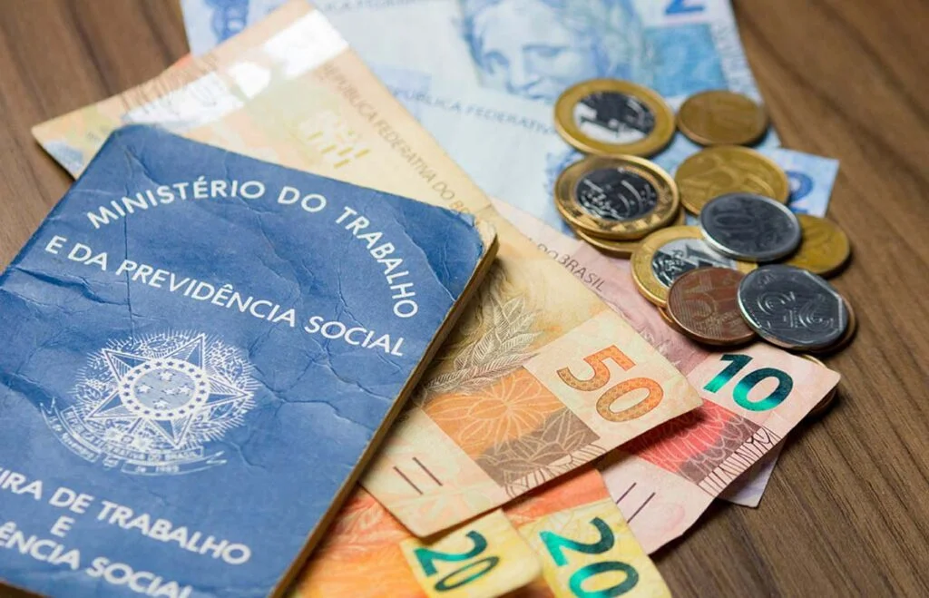 Imagem de uma carteira de trabalho com notas de dinheiro ilustrando o pagamento da contribuição assistencial.